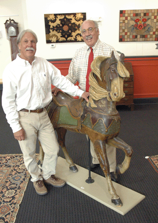 Jim Grievo, left, and Ron Pook, during the Friday night preview of the sale. The horse, a Philadelphia Toboggan Co., carved and painted pine carousel figure, circa 1900, by Charles Carmel, outside row, was estimated at $10/15,000, and sold below estimate at $8,888.