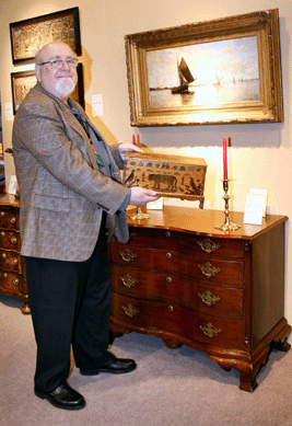 Longtime League member George Subkoff holds an American box, $5,500, decorated with an eagle and other animals about the time of the Centennial. The pair of English candlesticks is signed and dated Smith Carlisle, 1764, $9,500. The Connecticut cherry serpentine front chest of drawers was $25,000. 