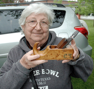 Marie Butchen, co-owner of Butchen Boys, Wantagh, N.Y., proudly displays a hardwood plane, perhaps lime oak, circa 1870, that was recently acquired in France. Such early tools were the lifeblood of French carpenters, thus the owner of this one had put his initials "C.Q.†in brass inlay. 