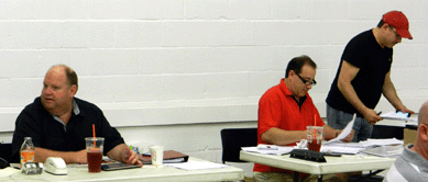 A last-minute check of phone lines and left bid was conducted by, from left, Ray Haradin, Leon Weiss and Steven Weiss.