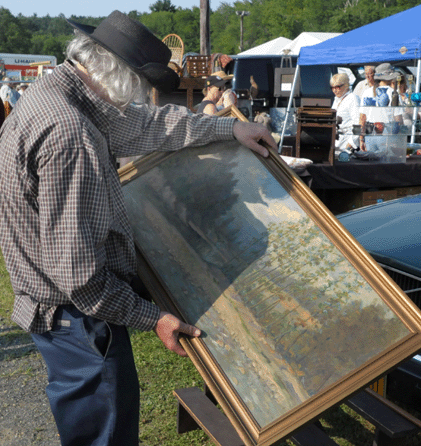 A shopper looks over a painting at J&J.