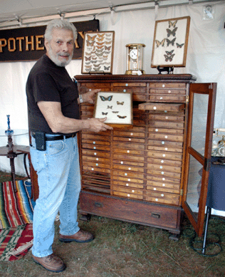 A barn find from Andover, Mass., this late 1800s cabinet featured some 60 drawers, each with several mounted butterfly specimens mounted under glass, shown here by co-owner Virgil Andrews of Digger's Antiques, New Bedford, Mass. ⁎ew England Motel