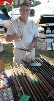 Jake Mathieu, Brimfield, Mass., displays a selection of early golf clubs and accessories. ⁊&J