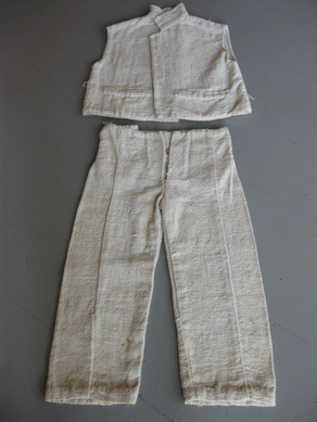 The sleeveless cotton jacket and trousers were hand spun and woven by slaves in Louisiana and worn by their children. The set, handed down in the family, is rare; most descriptions of slave children describe them as wearing a shirt or shift.