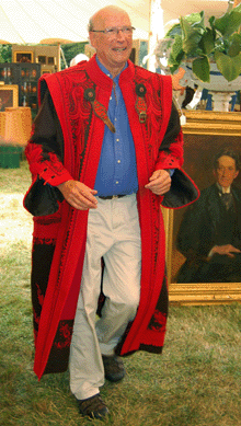 Alfred J. Walker models an embroidered wool Hungarian gentleman's coat that sold for $528. Before the sale, he addressed the gathered bidders paying tribute to auctioneers Frank McNamee and David Glynn, extolling their integrity and professionalism. Then he swept off to Newport to tend to a booth at the antiques show.