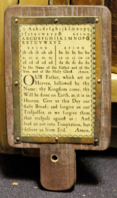 The horn-book, shown here at B&S Gventer Books & Ephemera, South Egremont, Mass., was the first primer made for children to handle. Originating in Fifteenth Century England, the tacked brass strips held the transparent sheet of animal horn in place as protection from grubby little fingers.