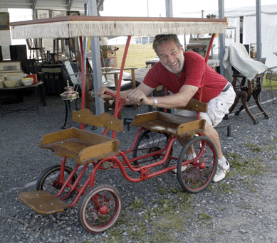 Paul Bessinger tests out this children's surrey for size that he and business partner Chris Velush of Seymour Fine Arts, Seymour, Conn., were offering.