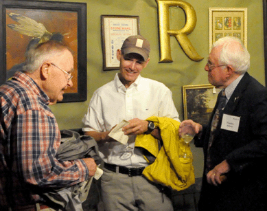 Cape Cod dealer Charley Adams, right, chats with clients during preview.