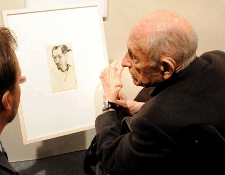 Artist Will Barnet looks over a drawing in a dealer's booth at the Works On Paper show in New York City in March 2008. Barnet, whose art is a mainstay in many of the booths throughout art fairs in America, was often seen at the shows. ⁁ntiques and The Arts Weekly photo by David S. Smith