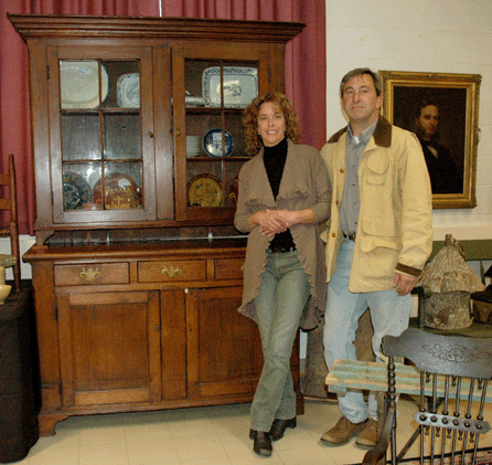 Brookfield Auction's co-owners Diana and Andy Onyshkewych with the two-piece Nineteenth Century cupboard that was the top lot of the sale at $2,875. From a Southbury, Conn., estate, the cupboard had glazed upper doors and bottom section comprising three short drawers over two doors.