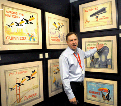 Robert Lloyd with a portion of the collection of interesting and colorful original oil on canvas advertising proofs for Guinness. Robert Lloyd, New York City.