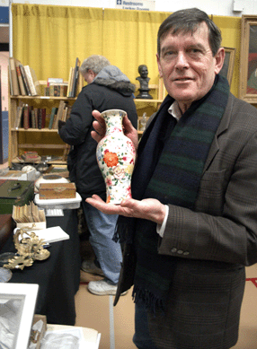 Norman Legassie of Stepping Stones Antiques, Old Saybrook, Conn., holds up a Chinese vase, Qianlong period.