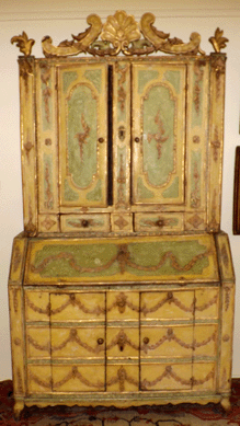 An Eighteenth Century Venetian two-part secretary with the original yellow paint with raised, carved and painted decoration realized $22,230.