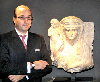 Hicham Aboutaam of Phoenix Ancient Art S.A., New York and Geneva, Switzerland. Aboutaam is urging more stringent restrictions on antiquities trading. He is pictured here with a Second Century AD limestone relief carving of a mother and child from Pymyra, an ancient Roman settlement that is now part of Syria.