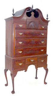 A circa 1770 flame mahogany bonnet top highboy with shell carving, flame finials and rosettes, and ball and claw feet sold for $9,900. 