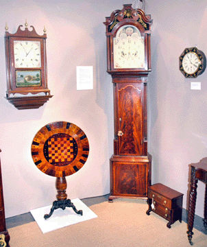 Star attraction at Charles F. Breuel Antiques, Glenmont, N.Y., was an English tall case clock, late Eighteenth Century, possibly by "Gillows†of Lancashire. Mahogany with mahogany veneers, the clock featured a wonderfully painted face decorated with floral spandrels and colorful, fanciful birds.