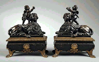 A rare pair of French portrait-headed bronze sphinxes, mid-Eighteenth Century, mounted by Cupids posed as holding urns (elements now lacking), on boullework sarcophagus stands, as a garniture de cheminée, sold for $31,200.