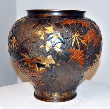 A signed Japanese Meiji period mixed-metal vase, with designs of autumn flowers in silver, gold and copper and borders of butterflies along the base and the neck, sold for $64,625.