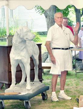 This photo of Dick Withington in tennis whites auctioning a statue of a firehouse dog was mounted onto a plaque and presented to Withington for his more than 60 years of dedication and service to the auctioneering profession.
