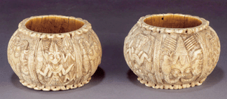 Carved ivory armlets such as this pair may have been part of the regalia of a Sixteenth to Eighteenth Century Yoruba (Nigeria) king. The motifs †heads with creatures coming out of their nostrils and fish-legged figures †evoke spiritual forces that shape the world and were controlled by a ruler.