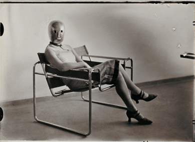 Erich Consemuller's striking photograph of a woman wearing a painted metallic theatrical mask by Oskar Schlemmer and a dress made in the Bauhaus weaving workshop sitting on a Breuer tubular-steel club chair appears to be a half automaton. The blank look of the mask conveys both robotic and foreboding messages. Private collection. ⁅state of Erich Consemuller photo