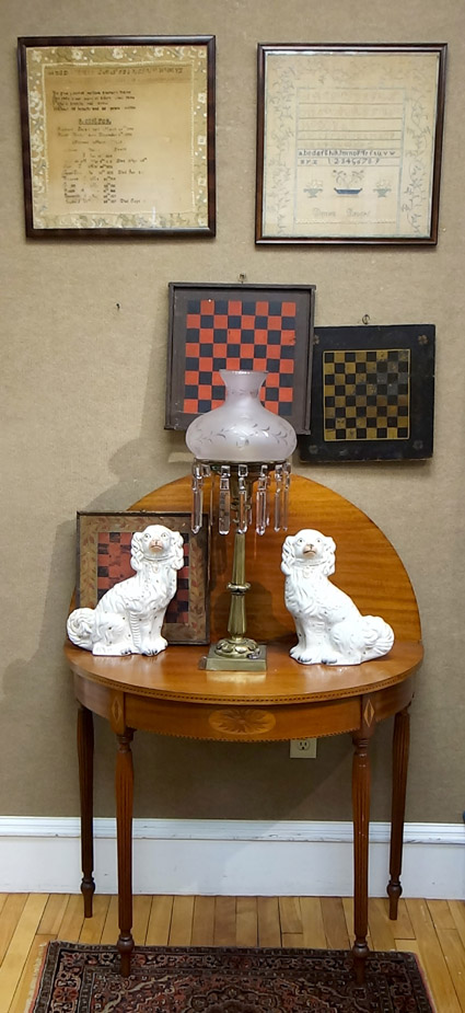 Centered around the Sheraton card table that sold for $ 258, this grouping included two samplers for $ 382, a pair of Staffordshire dogs in white for $ 192, and two game boards, one red and black and the other yellow and black, that brought $ 287.