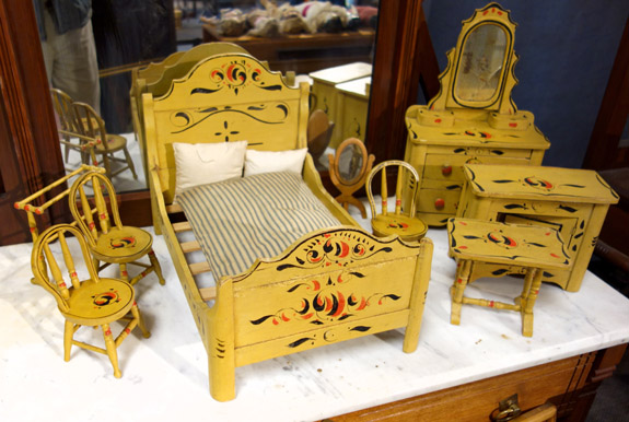 A set of miniature bedroom furniture, yellow painted with decoration, that brought $ 402.