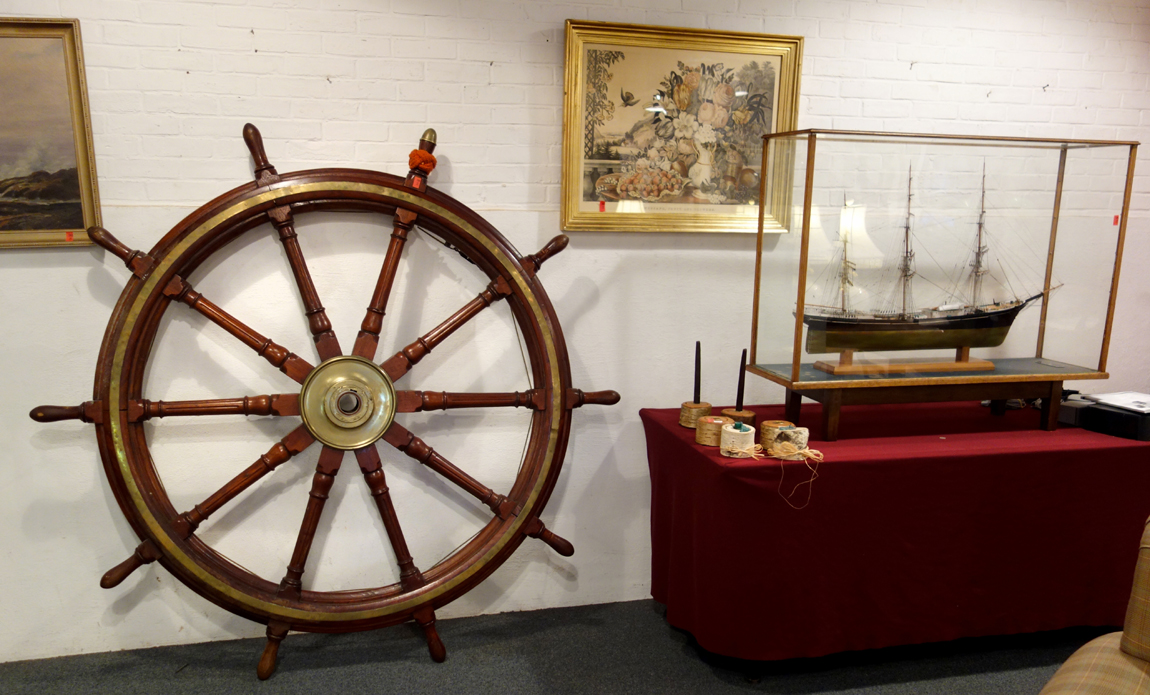 An antique ship’s wheel sold for $ 2,415, the ship model at right went for $ 575.