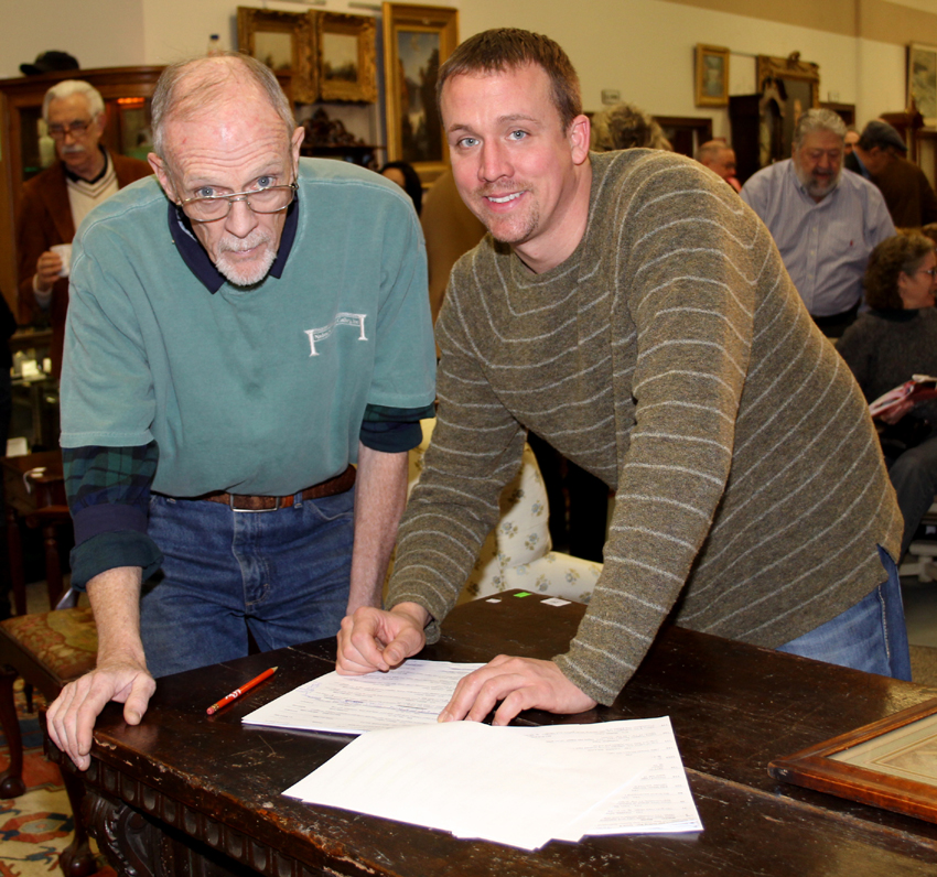Edwin J. Nadeau III, RIGHT, reviews absentee bids with staff before the sale.