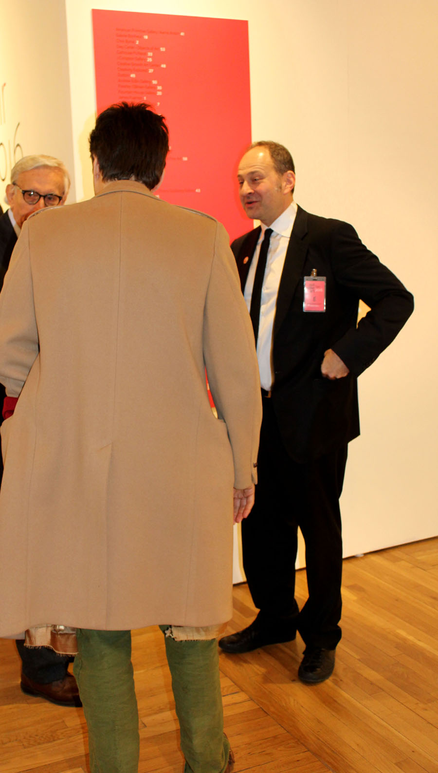 Andrew Edlin, chief executive officer of Wide Open Arts and gallerist,<br>conferring with show visitors.