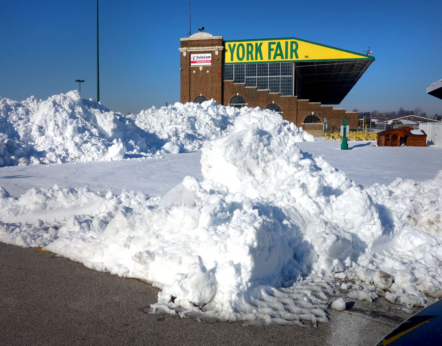 To make room for parking, machines piled the snow where possible, using an area near the grandstand and an intersection near the gate to the fairgrounds.