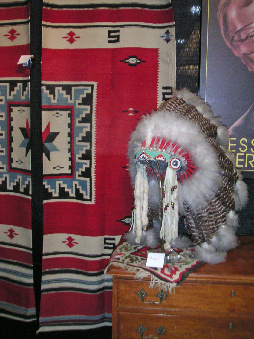 An interesting grouping of Native American Indian artifacts included this beadwork and feather headdress shown in front of two textile runners. Both items were from the 1940s and displayed at Cool Home Consignments, Morristown, N.J.