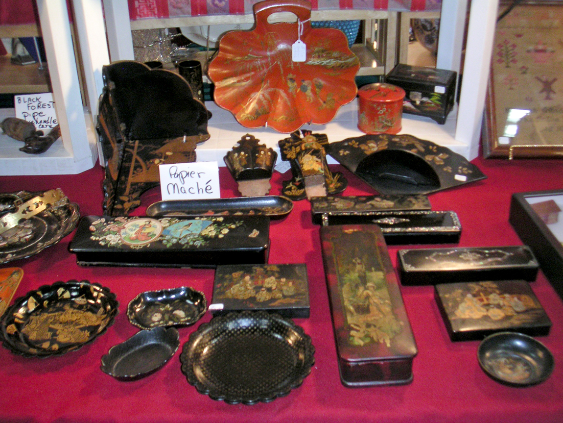 A large collection of Chinese lacquer papier mache at Lara Joyce Antiques, Westfield, N.J., had many unusual examples, including red lacquer with stars and red Asian designs, as well as an unusual inkwell made with rare abstract designs and a pin tray with a mother-of-pearl fruit decoration. Owner Lara Joyce pointed out that although the pieces had the flavor of the Orient, most were English.