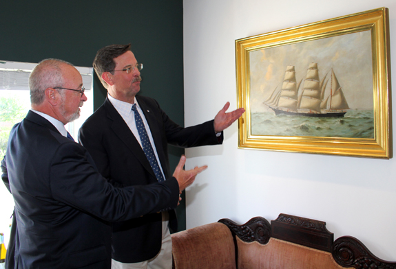 Eldred’s president emeritus and co-owner John Schofield and Stephen C. White, president of Mystic Seaport, inspect a Nineteenth Century painting of the Canadian barque <i>Lancefield</i>, captained by C.R. Grant. The painting is slated for Eldred’s mid-September Marine Arts auction.