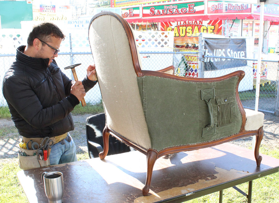 Elder Morales, Jefferson, Md., restores and creates bespoke furniture using vintage and unique fabrics like US Army duffle bags and German linen.<br>Here, he works on a French chair from the 1920s. —New England Motel