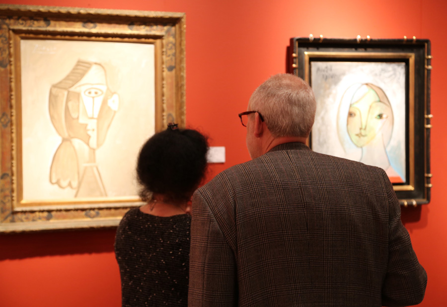 Patrons admire two Picasso oil paintings<br>at David Benrimon Fine Art, New York City.