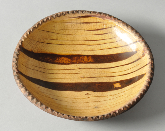 Collectors seem to love pairing early American furniture with earthy English pottery, as this 8-inch combware plate, $ 8,000, with a coggled rim and trailed slip decoration suggested.