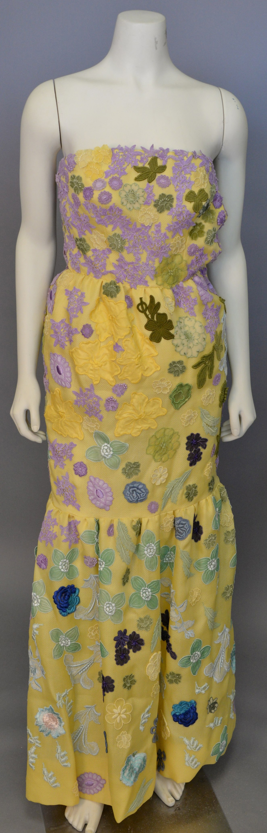 A Givenchy designer embroidered strapless dress, yellow appliquéd with multicolored flowers and leaves, went out at $ 2,000.