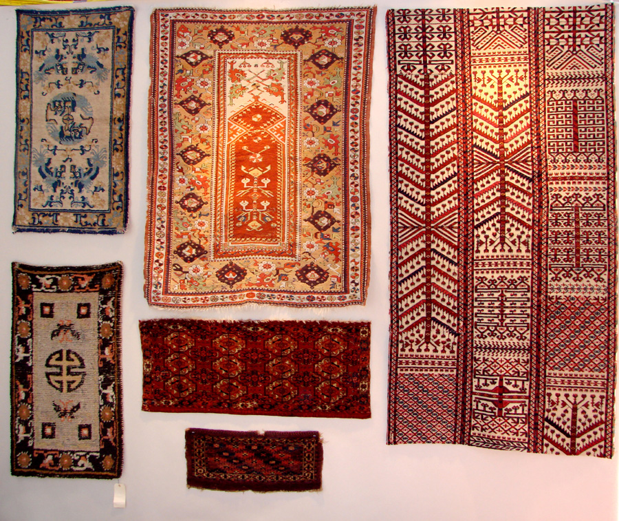 On one booth wall for Yoruk Rug Gallery, Chicago, is a Turkish Melas prayer rug (seen in middle) and to the right are three Turkomen tent bands that have been assembled together.