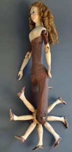At $5,750, the second highest priced item in the sale was this rare walking doll. The body was carved out of one piece of wood, and the elongated torso was cutout to accommodate eight legs, mounted on a wheel that gave the impression that the doll was walking when it was pushed. The head was painted, with black eyes, and it had an elaborate human hair wig. The wooden arms were jointed at the shoulder and elbows. This example was not dressed. A similar companion, with seven legs and antique clothes, brought slightly more, $6,095, making it the top lot of the two-day sale. Neither the auctioneer, nor anyone in the room, had seen other examples.