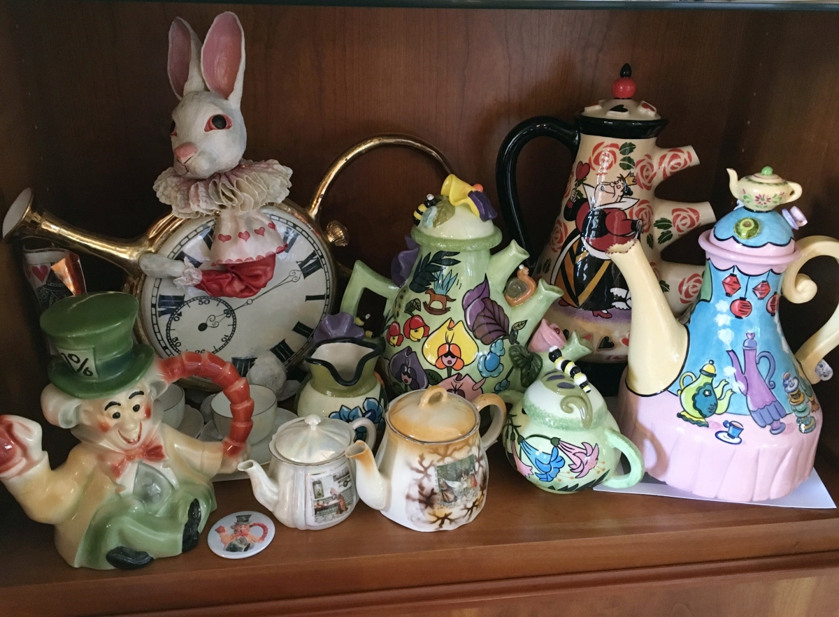 The three teapots on the right are by Elisabet Gomes. The tall white rabbit teapot is by an artist from Maine named Meryl Ruth. The teapot on the left is a Disney example from 1952 that was originally sold when the animated movie came out. The small teapot next to the Hatter was bought in an antiques store in Washington, D.C., and is made of lusterware. Next to it is another teapot from New Zealand with the same picture as the lusterware teapot from an early edition of Alice.