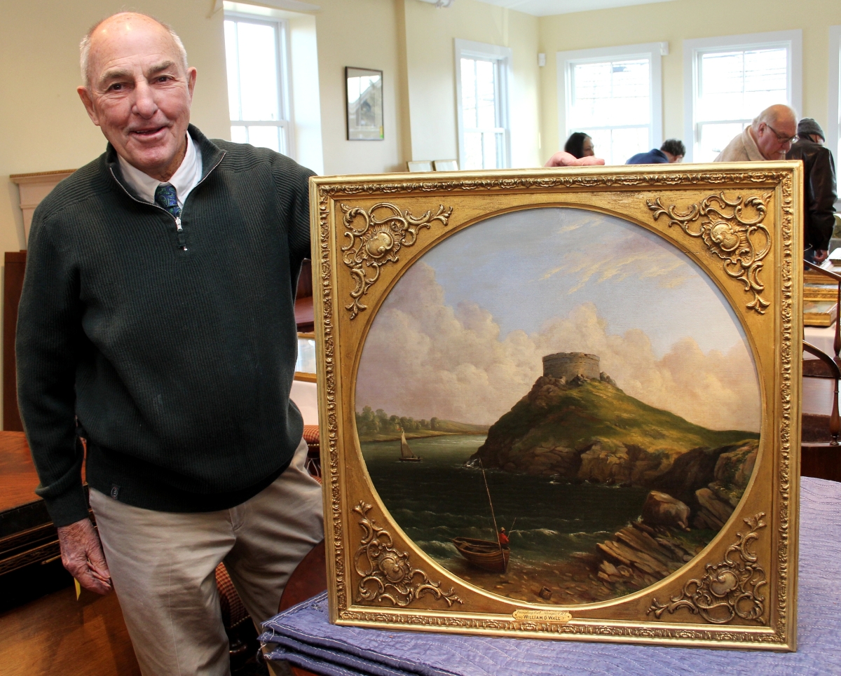 Auctioneer Mike Corcoran with the sale’s top lot, a view of Fort Dumpling, a Revolutionary War site in Jamestown, R.I. The painting, by Irish-born artist William G. Wall, brought $8,750. Wall lived in Newport, R.I., between 1828 and 1835.