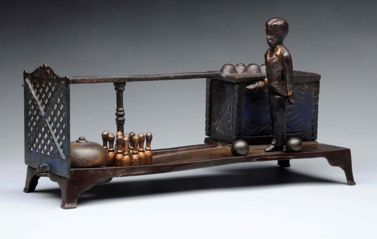 This cast iron mechanical bank, Kyser & Rex Bowling, 11½ inches long, was in very good condition and sold for $49,200, under the $60,000 low estimate. To operate this bank, insert a coin into one of the four slots and the bowler will lean forward to release the ball. The ball then knocks over the pins and rings a bell and to make ready again, straighten the bowler, reset the pins and place the ball back into his hands.