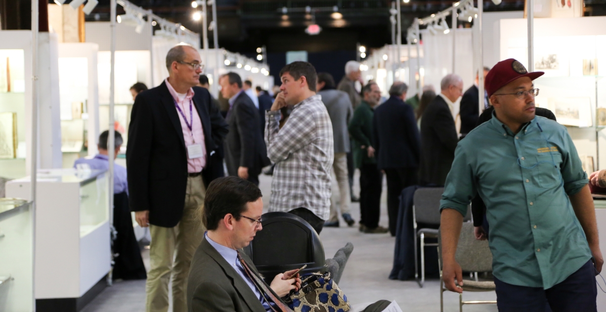 Visitors walk from booth to booth at the New York Antiquarian Book Fair.
