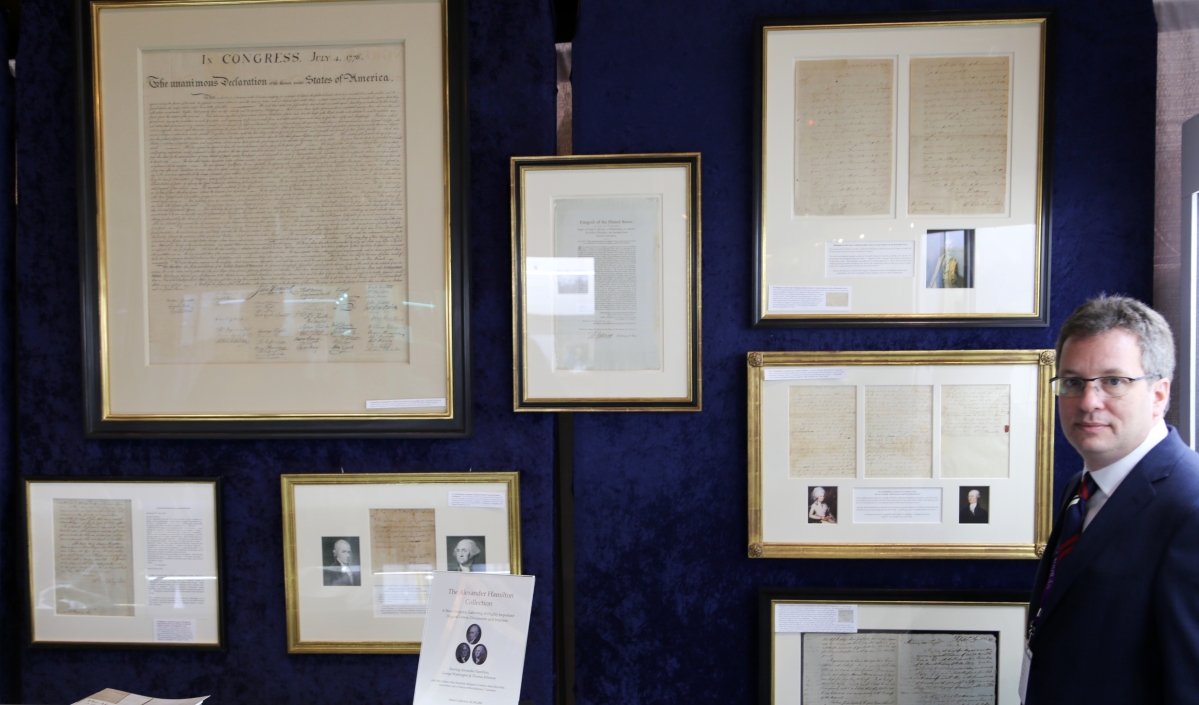 Seth Kaller, White Plains, N.Y., stands with a few select pieces of a larger collection of rare Alexander Hamilton and Revolutionary War documents, letters and imprints that both he and University Archives, Westport, Conn., offered at the show.