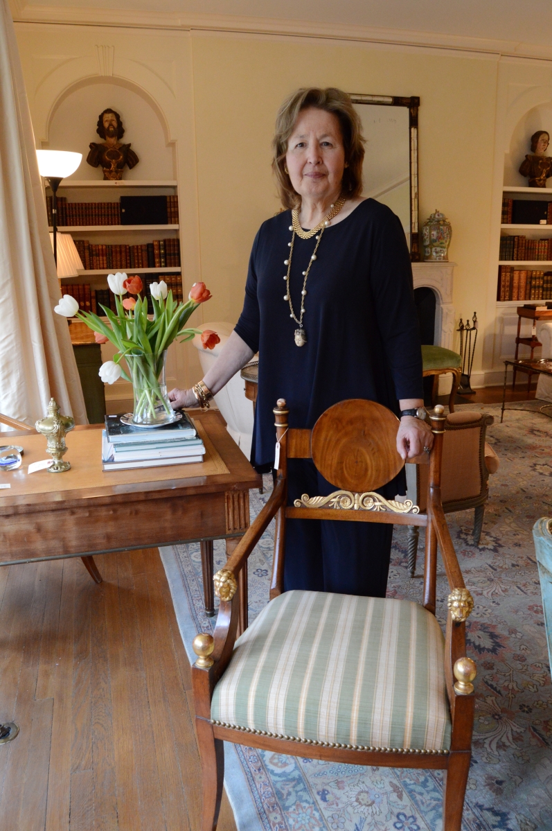Elizabeth Jackson poses in the parlor with a Russian chair with fine carving.