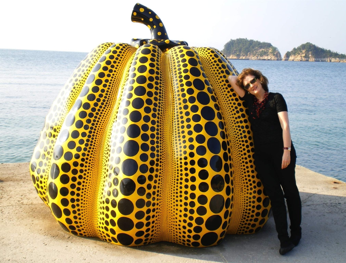 Art dealer Joan Mirviss at the museum island of Naoshima in 2013. The pumpkin sculpture is by contemporary artist Yayoi Kusama (b 1929). A traveling exhibition of the artist’s work remains at the Hirshhorn Museum and Sculpture Garden in Washington, DC, through May 14. Clockwise from upper left: Sançai vase by Kawai Kanjiro, circa 1922, glazed stoneware, 4 inches. “Wind Direction” by Fujikasa Satoko, 2016, unglazed stoneware, height 23½ inches. “Three Crabs on the Shore,” shikshiban surimono by Yashima Gakutei, circa 1827. Blue craquelure celadon long-necked vase by Okabe Mineo, circa 1969, glazed stoneware, height 10¼ inches.