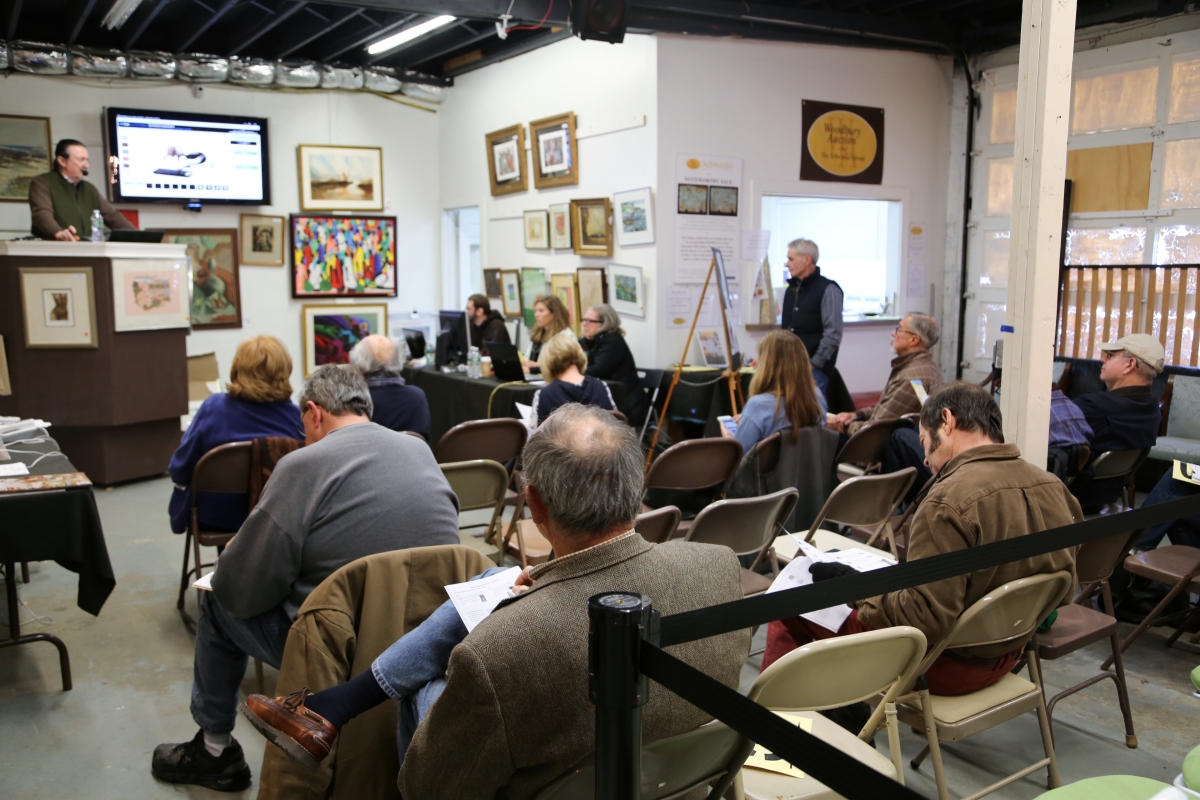 Tom Schwenke stands on the podium, left, in front of the gallery. Bidders still turned out for the Wednesday afternoon sale, though much of the bidding was online.