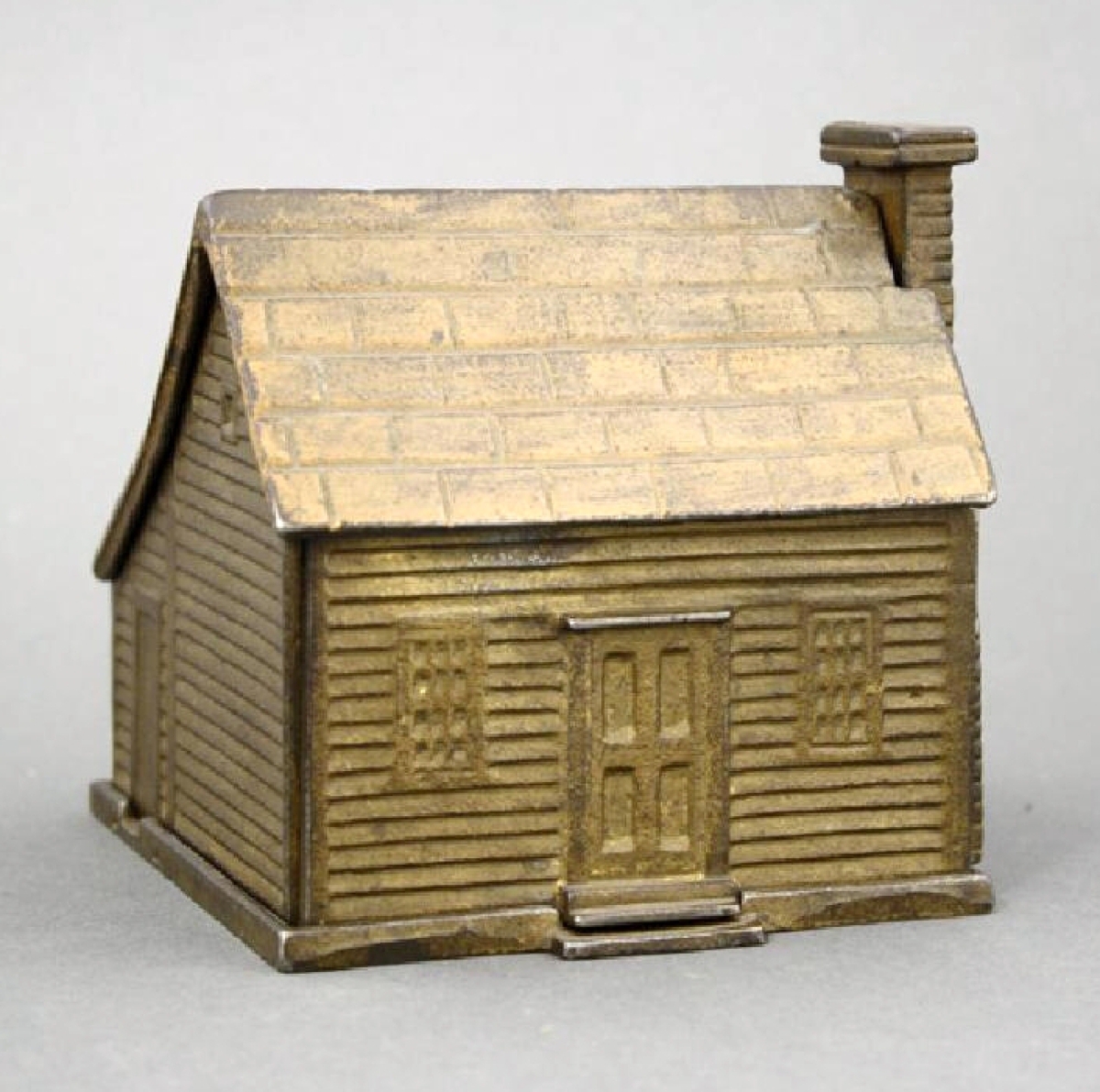 Only a handful of these colonial saltbox house banks exist, unknown maker, American, circa 1880s, and of cast iron. The bank is in pristine condition, provenance lists Donal Markey. The high estimate was $9,500, and the bank sold for $11,400.