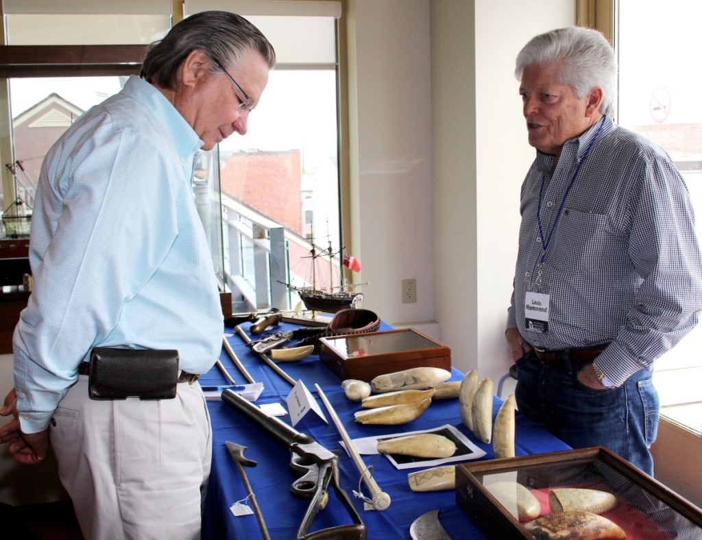 A collector, left, checks out scrimshaw offered by Florida dealer Lou Hammond. The show sets up in the museum’s Harbor View Gallery overlooking New Bedford’s wharves and the Acushnet River.